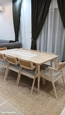 a wooden table and chairs in a living room at Nuha Homestay La Casa Lunas