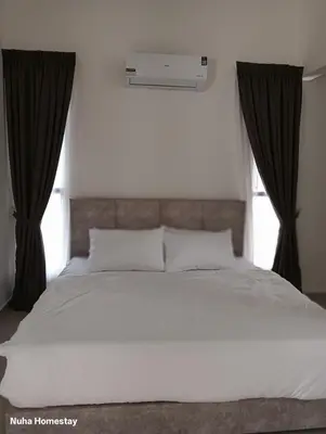 a bedroom with a white bed with black curtains at Nuha Homestay La Casa Lunas