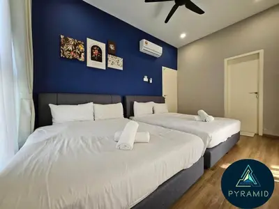 two beds in a bedroom with a blue wall at 3 Bed Rooms Cozy Unit The Cove in Ipoh