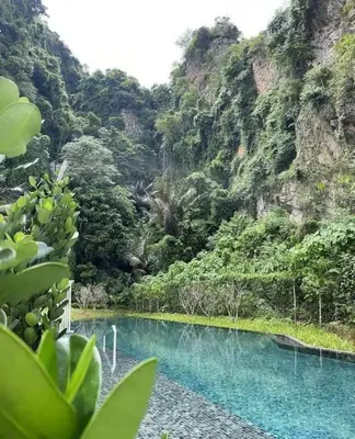 a pool of blue water in front of a mountain at 3 Bed Rooms Cozy Unit The Cove in Ipoh