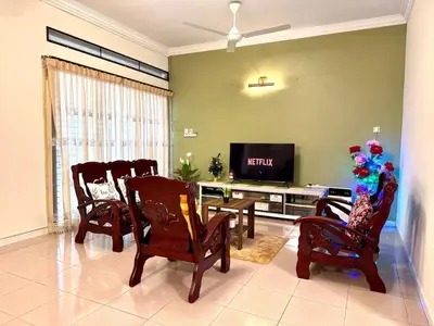 a living room with a table and chairs and a television at Simee Cozy Homestay ,Simee, Ipoh Town in Ipoh