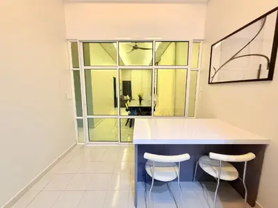 a kitchen with a counter and two stools at Adam Luxe Homestay Tapah in Tapah