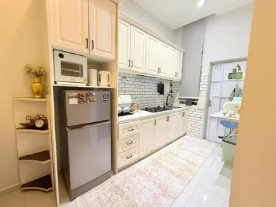 a kitchen with white cabinets and a refrigerator at Adam Luxe Homestay Tapah in Tapah
