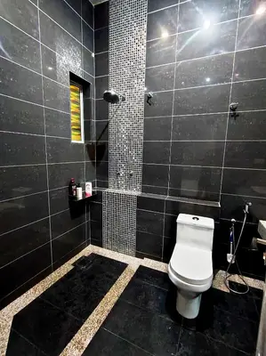a black bathroom with a toilet and a shower at Ipoh FamilyHub by One Life Four Season Guesthouse in Ipoh