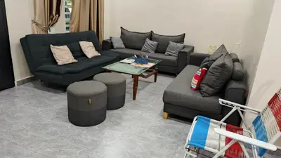 a living room with two couches and a table at Lapangan Sentosa Homestay Ipoh in Ipoh