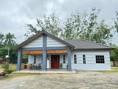 a small white house with a red door at Damai Homestay in Gua Sai