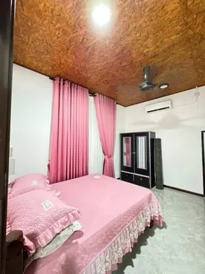 a bedroom with a pink bed with pink curtains at Damai Homestay in Gua Sai