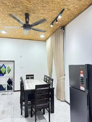 a dining room with a table and a ceiling fan at Damai Homestay in Gua Sai