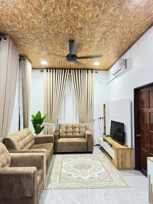 a living room with two couches and a tv at Damai Homestay in Gua Sai