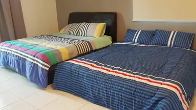 two beds sitting next to each other in a room at Woon homestay 2 in Balik Pulau