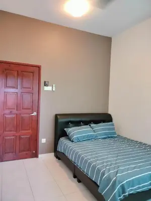 a bedroom with a bed with blue pillows and a red door at Woon homestay 2 in Balik Pulau