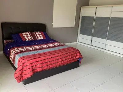 a bedroom with a bed with a colorful blanket at Woon homestay 2 in Balik Pulau