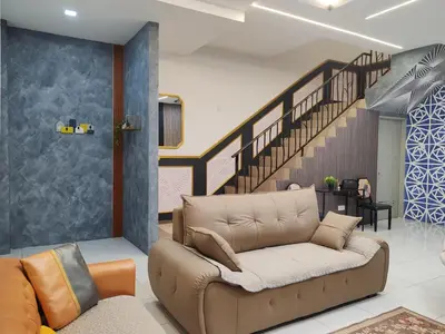 a living room with a couch and a staircase at Lahat Mines Signature Stay in Lahat