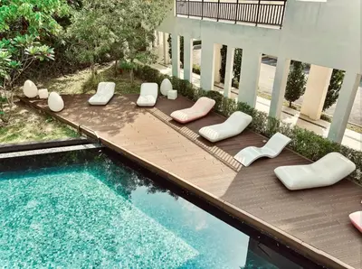 a patio with lounge chairs and a swimming pool at Ipoh The Cove Hillside Premier Suites By LUX SUITE in Ipoh