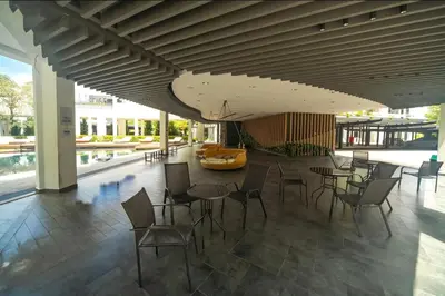 a lobby with tables and chairs in a building at Ipoh The Cove Hillside Premier Suites By LUX SUITE in Ipoh