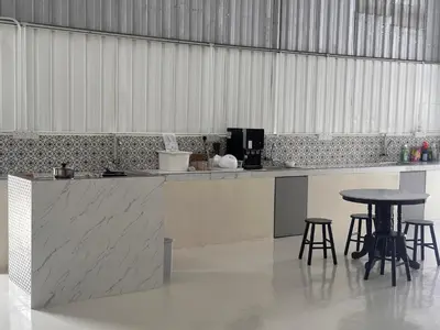 a kitchen with a counter and some chairs and tables at Lumen Stay in Bukit Mertajam