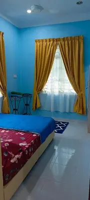 a bedroom with a bed and a window with curtains at ANAS Inn Homestay Balik Pulau, Penang in Balik Pulau