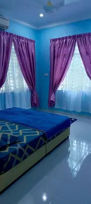 a blue bedroom with a bed with purple curtains at ANAS Inn Homestay Balik Pulau, Penang in Balik Pulau