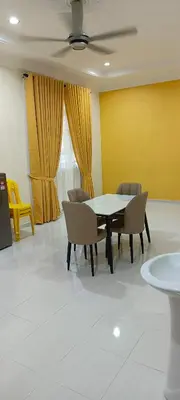 a dining room with a table and chairs and a yellow wall at ANAS Inn Homestay Balik Pulau, Penang in Balik Pulau