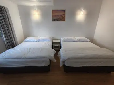 two beds in a room with white sheets at Little England B5-1 Fraser Panorama in Bukit Fraser