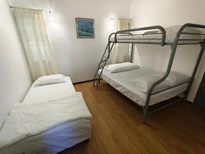 a bedroom with two bunk beds and a wooden floor at Little England B5-1 Fraser Panorama in Bukit Fraser
