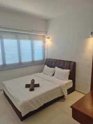 a bed with a teddy bear sitting on top of it at Sri Sayang Homestay 2 in Batu Ferringhi