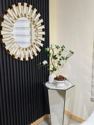 a mirror on a wall next to a table with a table sidx sidx at Qalsharyna Chalet inn in Simpang