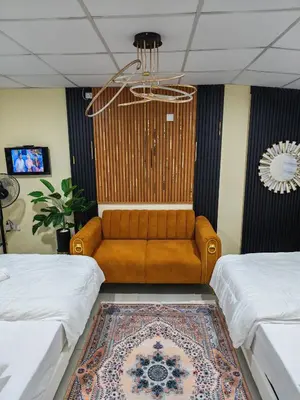 a living room with a couch in between two beds at Qalsharyna Chalet inn in Simpang