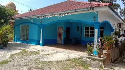 a blue and white house with a red roof at Zai homestay in Kampung Jeram Kawang