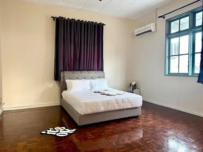 a bedroom with a bed and a pair of shoes on the floor at Bagan Cozy Family Retreat 4BR 10 Pax in Butterworth