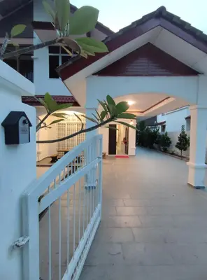 a white fence in front of a building at Sweet Home in Balik Pulau