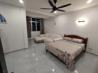 a bedroom with a bed and a couch and a ceiling fan at Sweet Home in Balik Pulau
