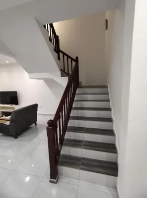 a staircase in a living room with a couch at Sweet Home in Balik Pulau