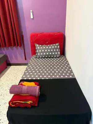 a bedroom with a black bed with polka dots at 786 Bali Top Homestay in Sungai Petani