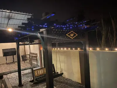 a gazebo with a swing and lights at night at TheBunga Homestay w Private Pool&Karaoke -Tronoh Perak in Teronoh