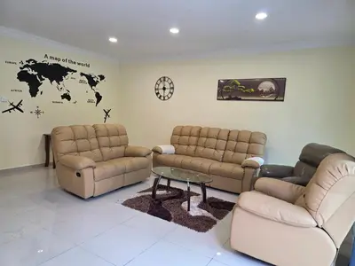 a living room with couches and a couch and a table at Teeview Homes in Tanah Rata