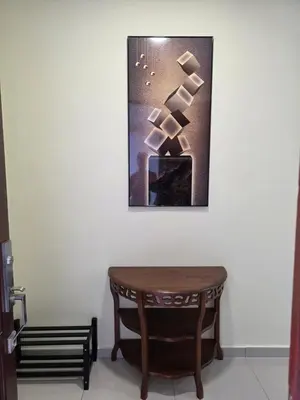 a table in a room with a picture on the wall at Teeview Homes in Tanah Rata
