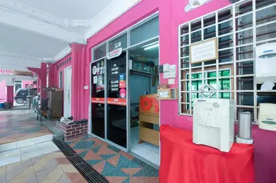 a pink shop with a red table in front of it at OYO 89984 Noris Wang Homestay in Kampong Banjar