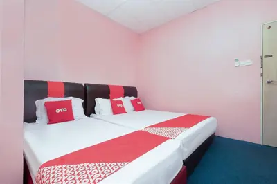 a bedroom with a bed with red and white pillows at OYO 89984 Noris Wang Homestay in Kampong Banjar
