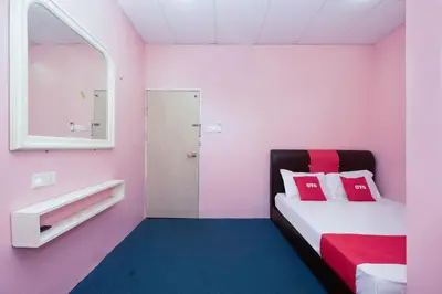 a pink room with a bed and a mirror at OYO 89984 Noris Wang Homestay in Kampong Banjar