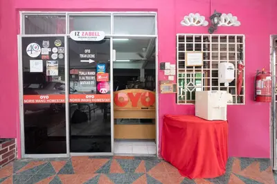 a pink building with a table in front of a store at OYO 89984 Noris Wang Homestay in Kampong Banjar