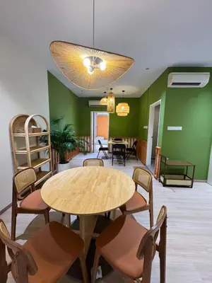 a table and chairs in a room with green walls at Penang Stay 2-6px Convenient Free parking in George Town