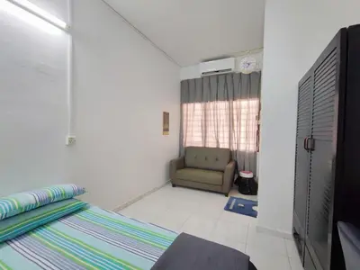 a bedroom with a bed and a chair in a room at Cozy Home near Airport, & Bayan Lepas Industrial in Bayan Lepas