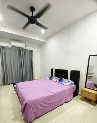 a bedroom with a purple bed and a ceiling fan at Teratak Nufal Homestay