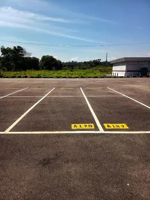 an empty parking lot with yellow signs on it at IFS Soho 3 Basic Home in Seri Iskandar