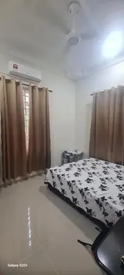 a bedroom with a black and white bed with curtains at Fauziah Sungai Besar Homestay in Sungai Besar