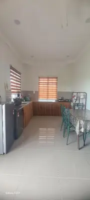 a kitchen with a table and chairs in a room at Fauziah Sungai Besar Homestay in Sungai Besar