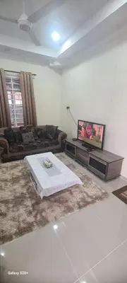 a living room with a couch and a tv at Fauziah Sungai Besar Homestay in Sungai Besar