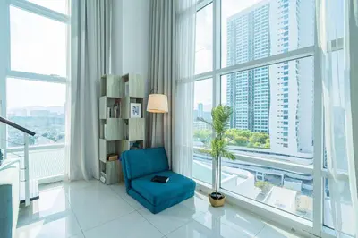 a blue chair in a room with large windows at 2BR Maritime Suite Duplex George Town SeaView in George Town