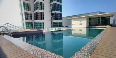 a building with a swimming pool in front of a building at 2BR Maritime Suite Duplex George Town SeaView in George Town